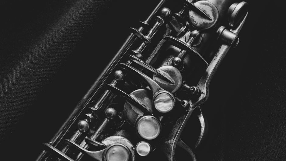 Artistic black and white close-up of saxophone keys, highlighting intricate details.